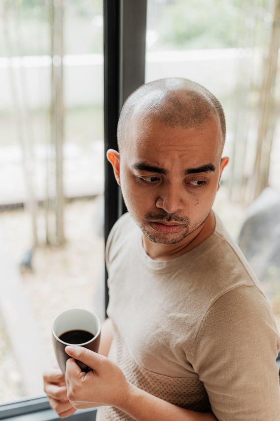 Man Drinking Coffee by the Window